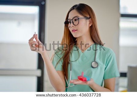 Portrait of a young pharmacist showing pills