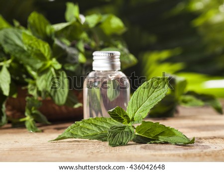 Essential aroma oil with peppermint on wooden background. Selective focus, horizontal.