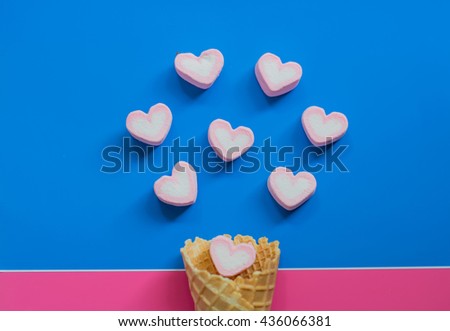 Ice cream cone and hearts on colorful paper background