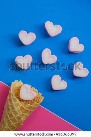 Ice cream cone and hearts on colorful paper background