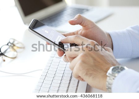 Close-up of financial professional man using his mobile phone while working at office. 