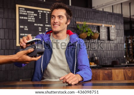 Man using mobile payment in a coffee shop