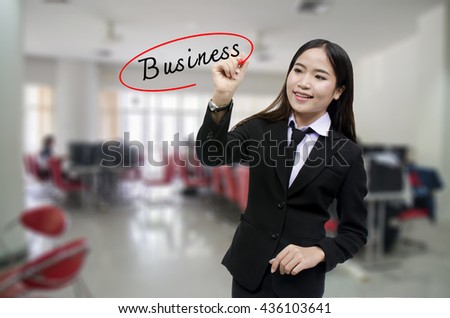 Businesswoman Hand writing business with black marker on visual screen. Isolated on gray background. Business, technology, internet concept. Stock Photo