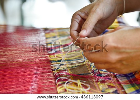 Hand of a woman weaving traditional silk fabric in Thailand Royalty-Free Stock Photo #436113097
