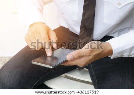 Close up image of man's hand is touching finger of mobile phone screen