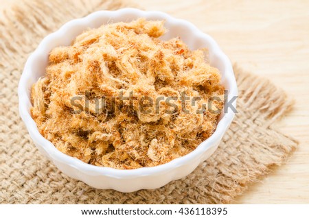 dried shredded pork in white bowl on wooden background. Royalty-Free Stock Photo #436118395