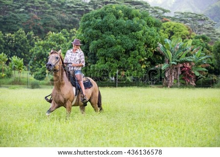 Mature woman riding horse in field