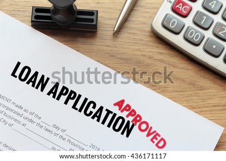 Approved loan application with rubber stamp and calculator concept Royalty-Free Stock Photo #436171117