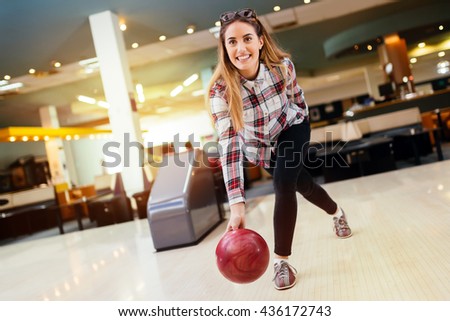 Woman throwing bowling ball in club