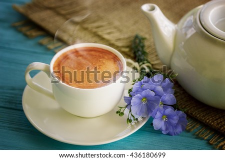 Coffee mug with blue flowers and notes good morning on blue rustic table from above, breakfast 