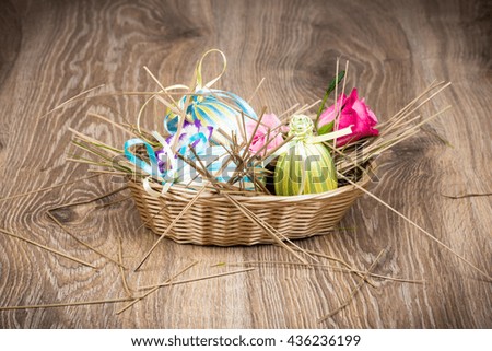 Easter eggs in the wicker on wooden background