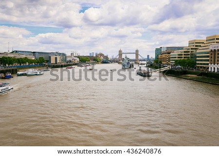 Thames river in London overlooking to tower bridge with a cloudy sky