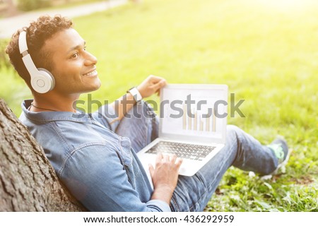 Cheerful young man is enjoying melody in nature