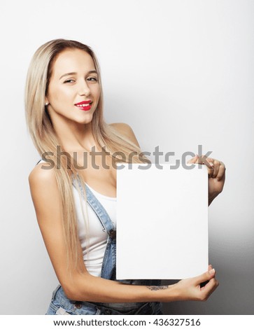 Smiling young casual style woman showing blank signboard, over white background isolated