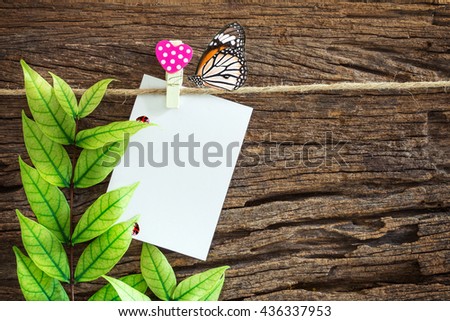 The Blank paper note hanging by red heart clips on wooden background 