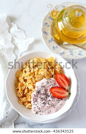 Healthy breakfast: corn flakes in bowl, yogurt, strawberries and chia seeds