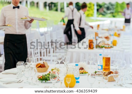 Waiters in uniform served tables for a banquet Royalty-Free Stock Photo #436359439
