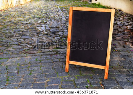 Empty chalkboard or blackboard on the street with copyspace. Blank menu board with space for text.