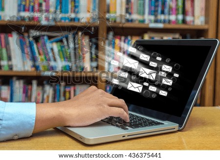 Hand typing on laptop computer with email and network line over the wood table in library, Education Technology concept