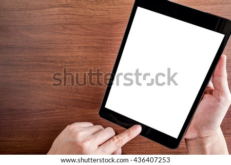 Hand touch on empty screen of tablet above brown table top view, Leave space for display of your content, Technology concept.