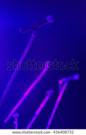 Microphone on stage, blurred picture for background.