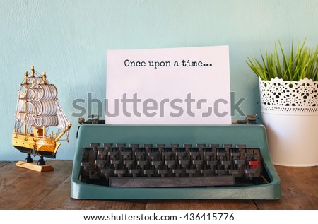 photo of vintage typewriter with phrase: ONCE UPON A TIME, on wooden table