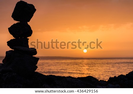 Beautiful sunset on the evening sea, rocks in the foreground