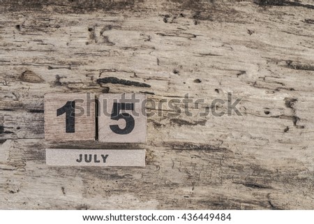cube calendar for july on wooden background with copy space