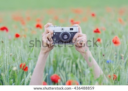 Photographing girl in a poppy field