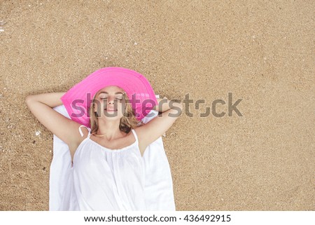 portrait of beautiful lying down relaxing on the sand on during summer holidays with copy space