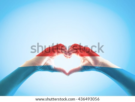Luxembourg flag pattern on people heart shape hands
