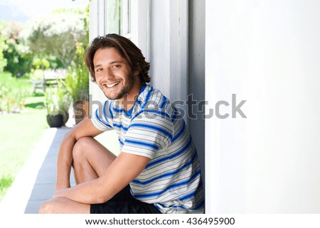 Portrait of smiling young man sitting on patio outside