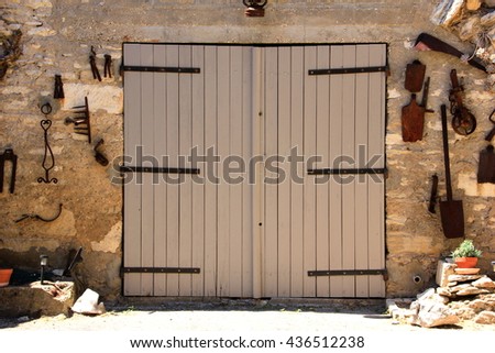 Wooden barn door with old tools Royalty-Free Stock Photo #436512238