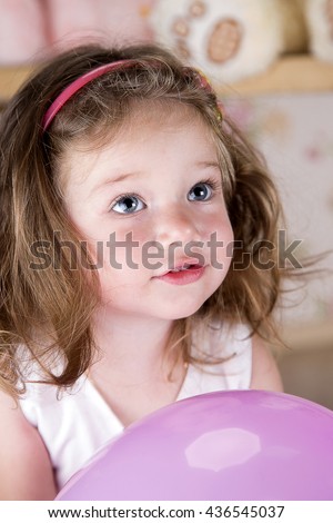 beautiful little girl looking up. Studio photography. portrait. in the hands of a girl's pink balloon inflated