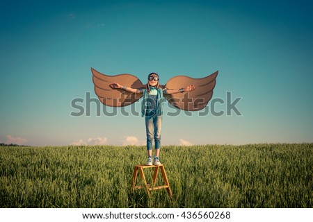 Happy kid playing. Child having fun outdoors. Kid with cardboard wings. Child in summer field. Travel and vacation concept. Imagination and freedom concept Royalty-Free Stock Photo #436560268
