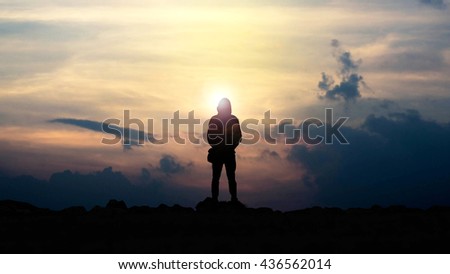 silhouette of man looking towards the sunset