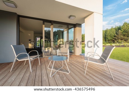 Modern villa with patio, simple outdoor furniture set