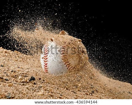 Baseball ball falling in a sand