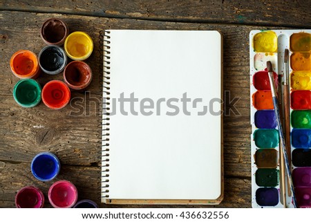 Art of Painting. Painting set: paper, brushes, paints, watercolor, acrylic paint on a wooden background top down view
