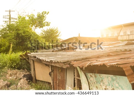 The old Thai style metal sheet house in the countryside of Thailand evening time, old abandoned home with a rusty tin roof