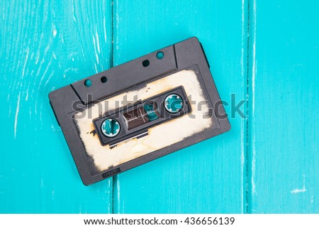 Old vintage cassette on a blue wooden background