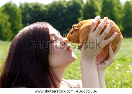 The girl kisses a home guinea pig