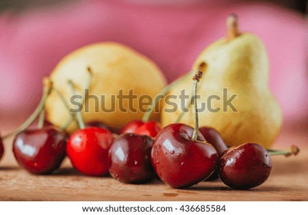 cherries and pear, fresh fruits on wooden table