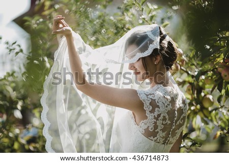 gorgeous fragile  woman  standing against a background of green trees