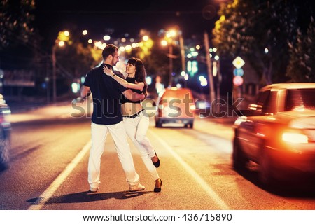 young couple dancing on the road