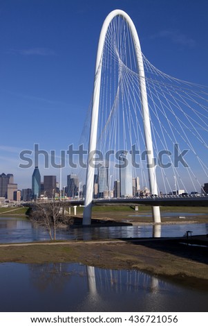 The new Margaret Hunt Hill Bridge that crosses the Trinity River with downtown Dallas, Texas in the background. The bridge uses a unique design of a 400-foot steel arch and cables.