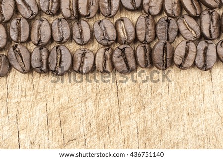 Coffee beans organized on grunge wooden background with copy space.