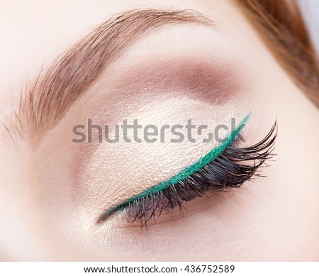 Closeup shot of female face makeup with closed eye and green eyeliner Royalty-Free Stock Photo #436752589
