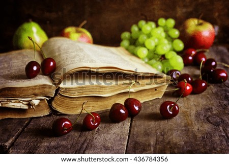 retro book on wooden background and cherry berry
