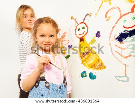 Cute little girls with brushes drawing funny bugs
